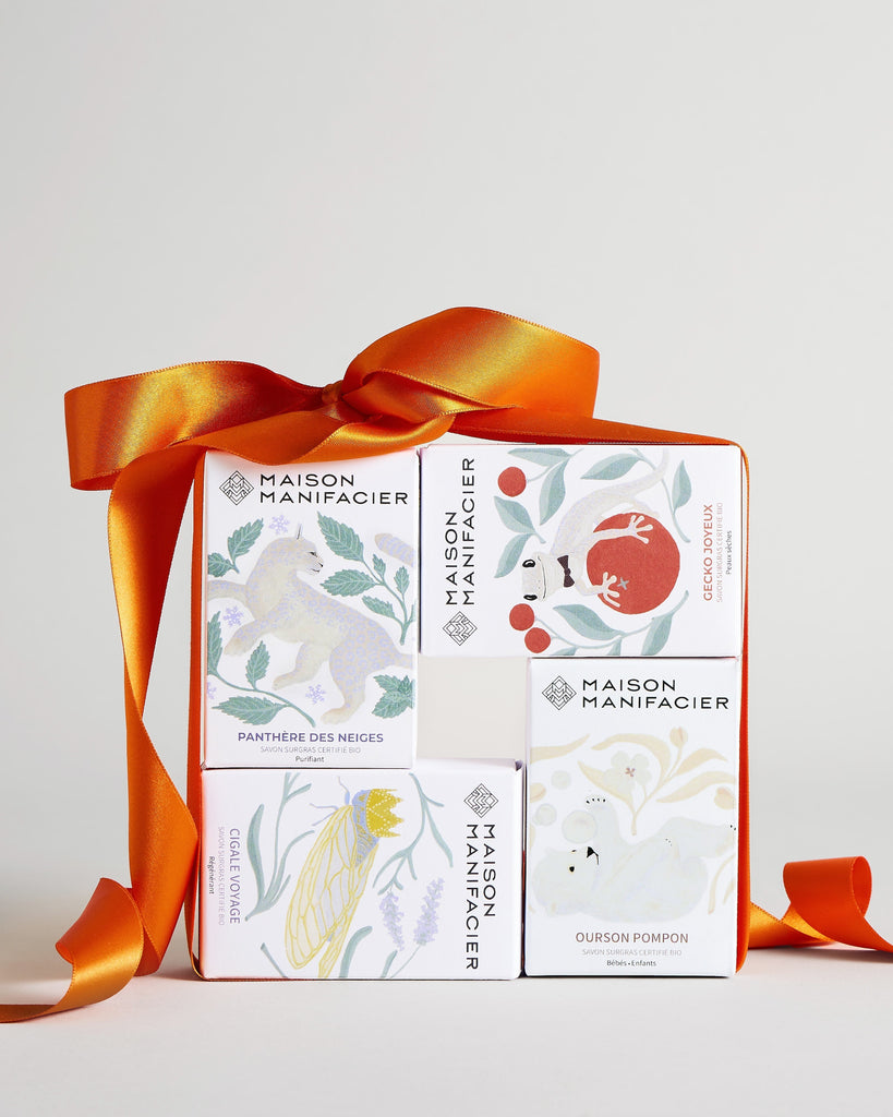 Quatre boite de savons emballées par un gros ruban orange